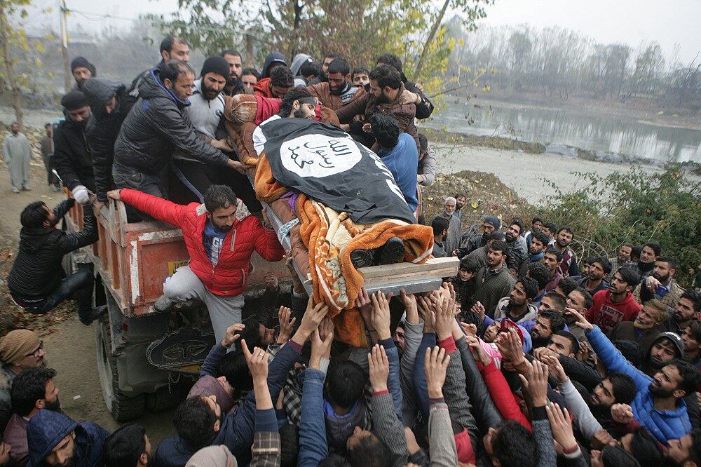 Mourners lift up the black flag-covered body of Mugees Ahmad Mir, a suspected militant, in Srinagar, Kashmir, Nov. 18, 2017.