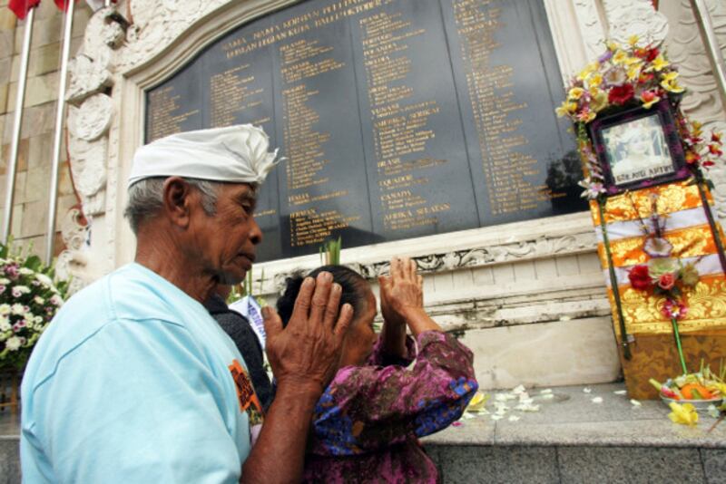 A Balinese couple prays at a Bali bomb memorial in Kuta to remember their daughter who was killed in the 2002 terrorist attacks on the Indonesian island, Oct. 12, 2010.