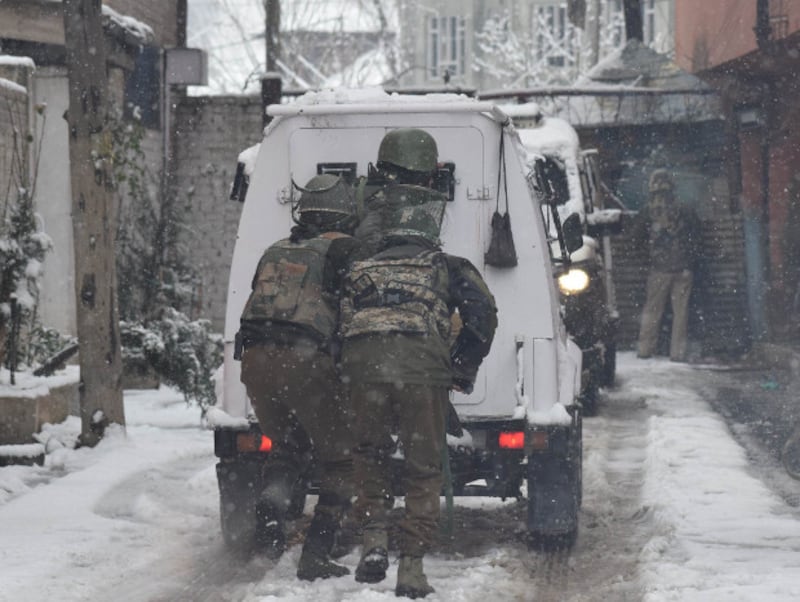 Paramilitary security personnel hide behind a bullet-proof vehicle during a gunfight with suspected LeT militants near their camp in Srinagar, Feb. 12, 2018. [Sheikh Mashooq/BenarNews] 