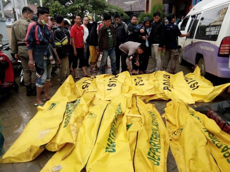 Korban tsunami yang tewas ditaruh dalam kantong-kantong jenazah di Carita, Pandeglang, Banten, pada 23 Desember 2018, setelah wilayah tersebut sehari sebelumnya diterjang tsunami yang dipicu oleh erupsi Gunung Anak Krakatau. (AFP) 