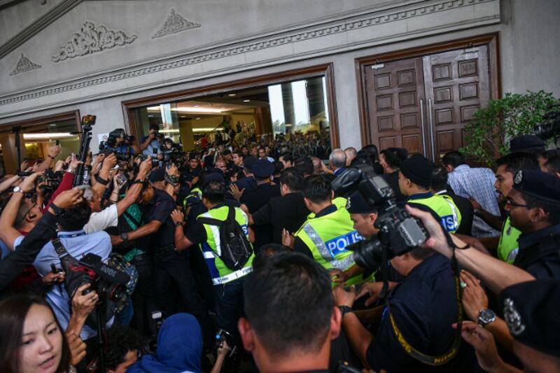 Photographers strain to get a picture of former Prime Minister Najib Razak at the Kuala Lumpur court complex, July 4, 2018.