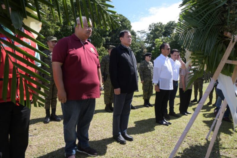 Philippine officials led by Task Force Bangon Marawi chairman Eduardo del Rosario (in black) and Presidential Peace Adviser Carlito Galvez (in white) lay a wreath at a marker in honor of more than 160 soldiers and police killed during the five months of fighting in Marawi City, Oct. 17, 2019. [Froilan Gallardo/BenarNews]