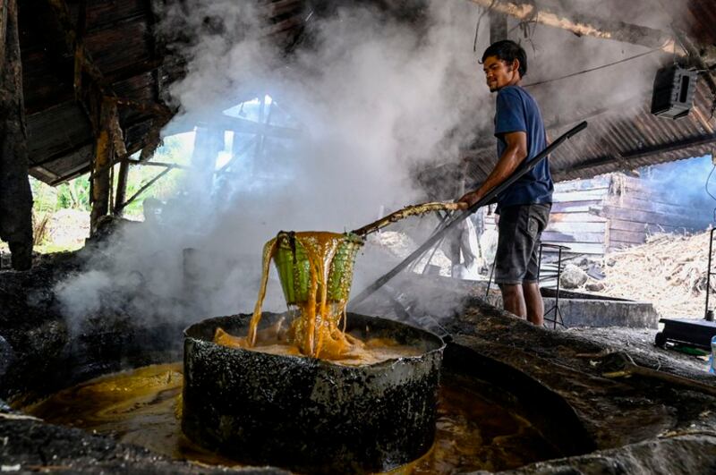 Seorang warga mengolah tebu untuk menghasilkan gula merah di industri rumah tangga di Ketol, Aceh Tengah, 19 September 2022. [Chaideer Mahyuddin/AFP]