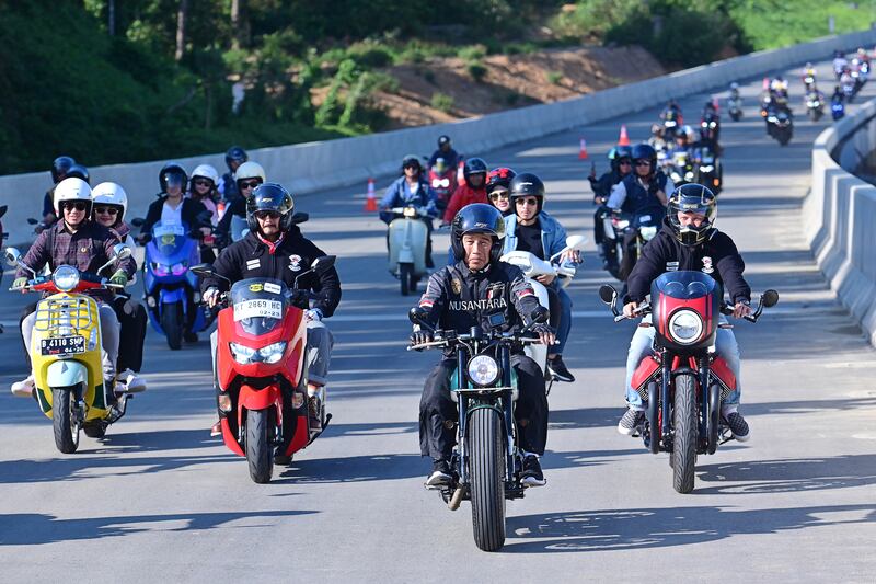 Presiden Indonesia saat itu Joko "Jokowi" Widodo (kedua dari kanan) mengendarai sepeda motor saat meninjau kemajuan jalan tol baru yang menghubungkan ibu kota baru Nusantara ke kota terdekat Balikpapan, di Kalimantan Timur, 28 Juli 2024. [Istana Kepresidenan Indonesia/melalui AFP]