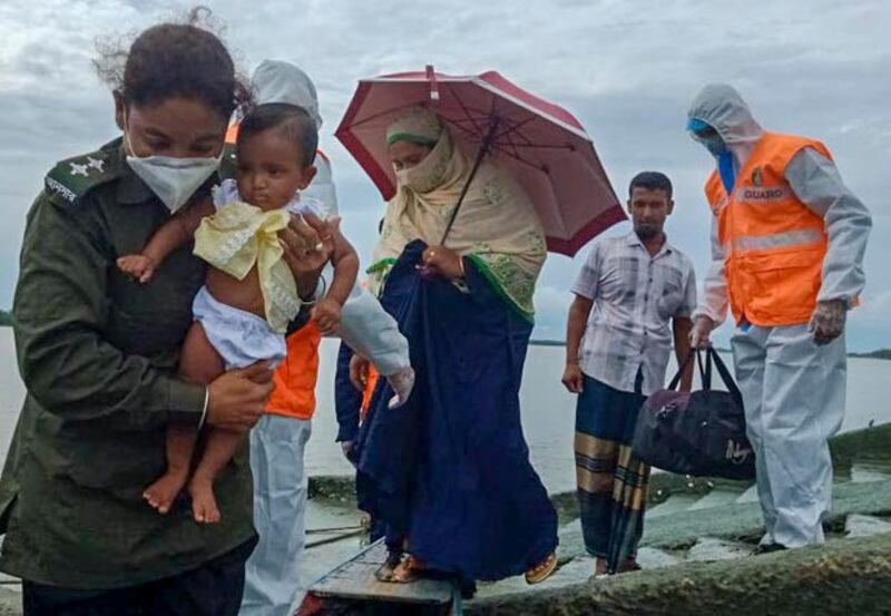সাতক্ষীরায় ঘূর্ণিঝড় আম্পানের কারণে একটি পরিবারকে আশ্রয় কেন্দ্রে সরিয়ে নিতে সহায়তা করছেন একজন আনসার সদস্য। ২০ মে ২০২০। 