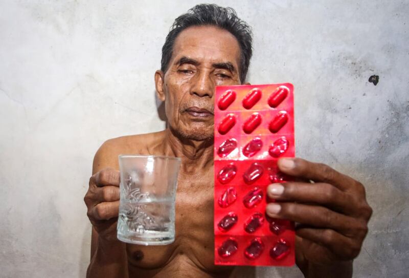 Seorang warga yang berdomisili tidak jauh dari PLTU Suralaya di Cilegon, Banten, memegang obat yang harus diminumnya karena ia menderita infeksi saluran pernapasan akut. Foto diambil pada 20 Oktober 2024. [Eko Siswono Toyudho/BenarNews]