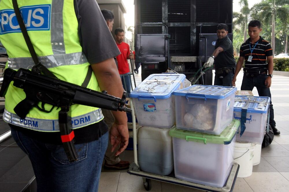 Polis Malaysia berdiri pengawal berhampiran bahan bukti kes dadah melibatkan warga Mexico di luar sebuah mahkamah di Kuala Lumpur. 27 April 2011.