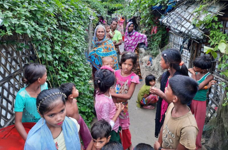 টেকনাফের বাহারছড়া শরণার্থী শিবিরে সামনে দাঁড়িয়ে আছেন একদল রোহিঙ্গা। ১৬ আগস্ট ২০২০।