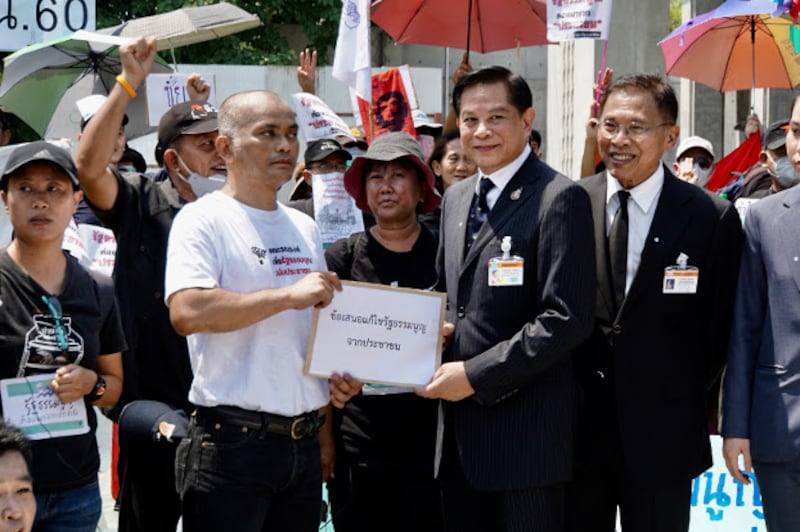 Anusorn Unno of Thammasat University submits the protesters' demands to Pirapan Salirathavibhaga, an adviser to Prime Minister Prayuth Chan-o-cha, in front of parliament, March 13, 2020. [Nontarat Phaicharoen/BenarNews] 