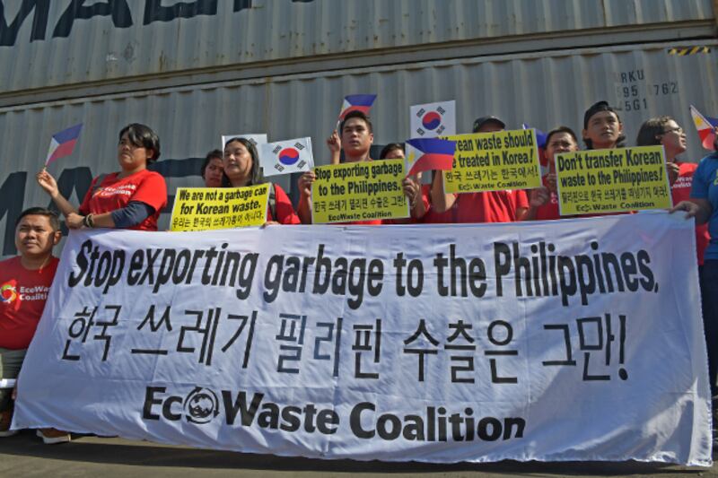 Activists with the Ecowaste Coalition, an environmental group, stage a rally in front of container vans loaded with household waste at the Mindanao Container Terminal in Tagoloan, Misamis Oriential province, southern Philippines, Jan. 13, 2019. (Froilan Gallardo/BenarNews)