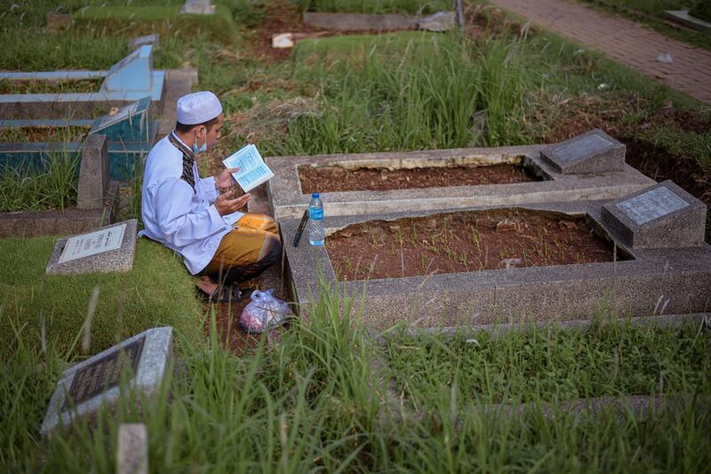 Seorang Muslim melantunkan doa di kuburan keluarganya pada hari Idulfitri di sebuah pemakaman di Jakarta, 2 Mei 2022. [AFP]