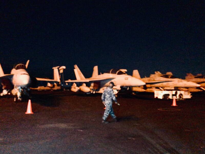 A crewmember walks by a flight line of fighter jets aboard the USS Theodore Roosevelt during a visit by the American aircraft carrier to Manila Bay, April 13, 2018.[Felipe Villamor/BenarNews] 