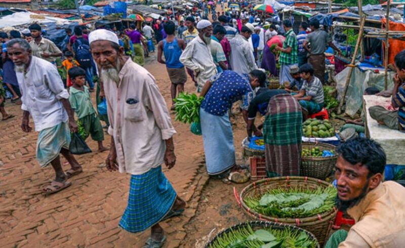 A Rohingya man (R) from Myanmar sells betel leaves at a market at the Kutupalong refugee camp in Ukhia, Cox's Bazar district, southeastern Bangladesh, July 21, 2019. AFP