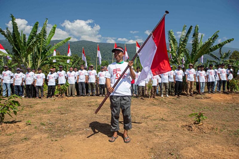 Seorang mantan narapidana terorisme mengibarkan bendera merah putih seusai mengikuti kegiatan pembentangan bendera merah putih di kaki Gunung Biru, Desa Pantangolemba, Kecamatan Poso Pesisir Selatan, Poso, Sulawesi Tengah, Jumat, 16 Agustus 2024. [Taufan Bustan/BenarNews]