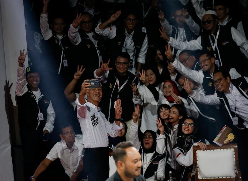Ganjar Pranowo, calon presiden dari Partai Demokrasi Indonesia Perjuangan berfoto bersama para pendukungnya dengan memperlihatkan salam 3 jari pada saat debat para kandidat presiden yang disiarkan televisi di Komisi Pemilihan Umum di Jakarta, 12 Desember 2023. [Ajeng Dinar Ulfiana/Reuters]