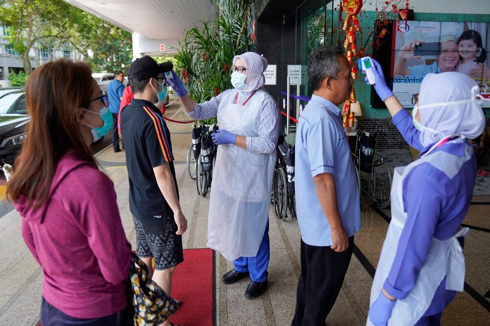 Jururawat sedang memeriksa suhu pelawat sebagai sebahagian daripada prosedur pemeriksaan jangkitan koronavirus di sebuah hospital di Kuala Lumpur, Malaysia, 5 Februari, 2020.