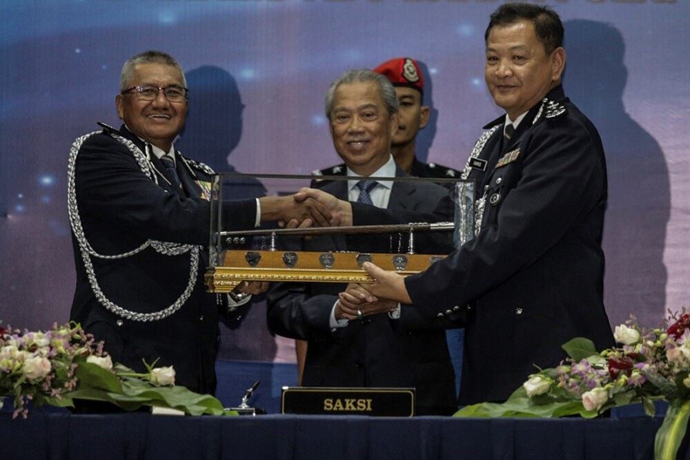 Mohamad Fuzi Harun (kiri) bersalaman dengan Abdul Hamid Bador (kanan) yang menggantikannya sebagai Ketua Polis Negara sambil disaksikan Menteri Dalam Negeri Muhyiddin Yassin pada majlis serah tugas jawatan tertinggi polis Malaysia itu di Kuala Lumpur, 3 Mei 2019.