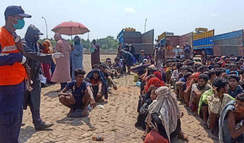 A Bangladesh Coast Guard member lines up rescued Rohingya outside the Bangladesh-Myanmar transit center at Teknaf, Cox's Bazar, April 16, 2020. [Abdur Rahman/BenarNews]