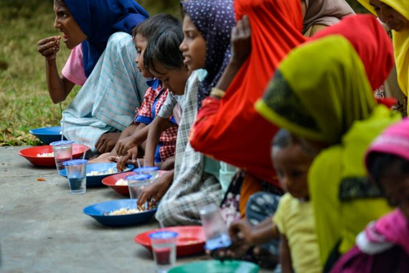 Pengungsi Rohingya makan di tempat penampungan sementara setelah kedatangan mereka dengan perahu di Laweueng, Pidie, Aceh, 27 Desember 2022. [Chaideer Mahyuddin/AFP]