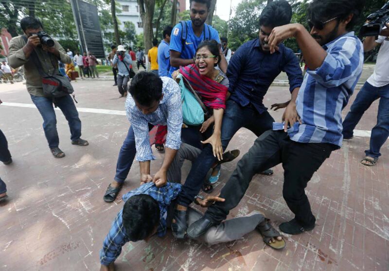 A Bangladeshi man protesting in favor of reforms to quotas for civil service jobs is attacked by counter-demonstrators in Dhaka, July 2, 2018. [BenarNews]