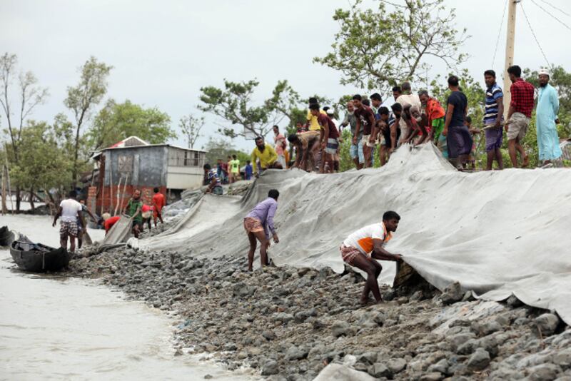 সাতক্ষীরায় ঘূর্ণিঝড় আম্পানের প্রভাবে জলোচ্ছাসে ভেঙে যাওয়া বাঁধ মেরামত করছেন গ্রামবাসীরা। ২১ মে ২০২০। 