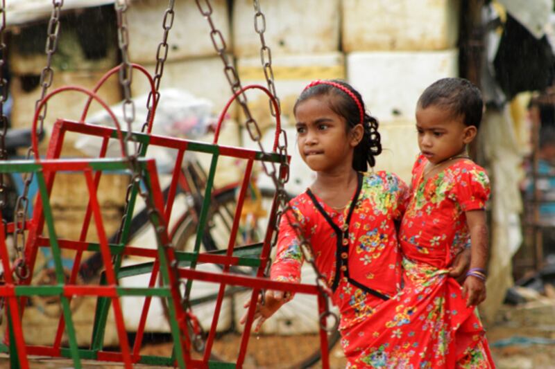 A Rohingya girl helps her sister get on a ride at the Eid-ul-Adha fair at the Kutupalong refugee camp in Ukhia, Cox's Bazar, Aug. 22, 2018. (Sharif Khiam/BenarNews)