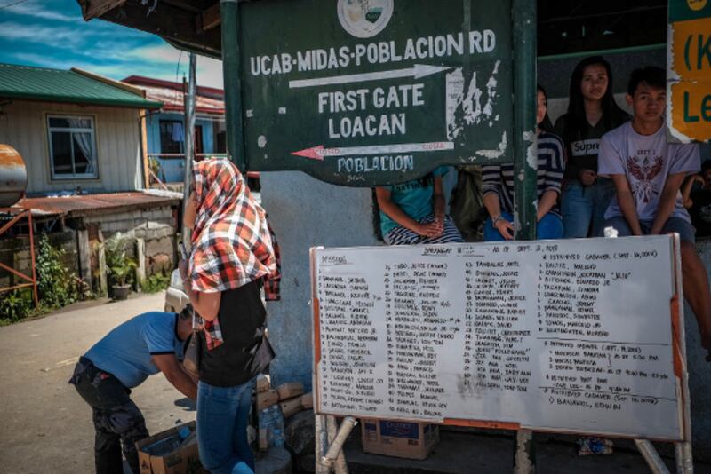 Names of missing persons and people whose bodies were recovered after the landslide are listed on a white board in Itogon, Philippines, Sept. 18, 2018.