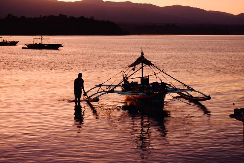 A fisherman positions his boat after unloading his catch at dawn in Masinloc, Feb 27, 2024. (Jojo Riñoza/BenarNews)