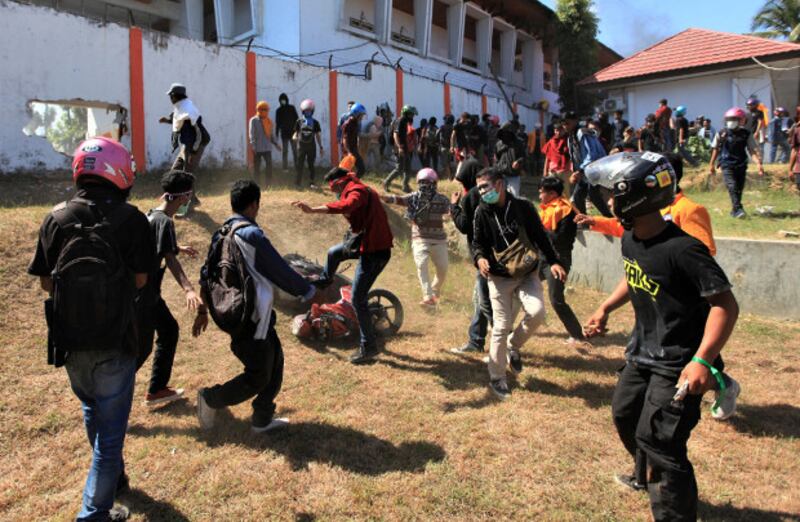 Para mahasiswa merusak sebuah sepeda motor di lokasi gedung DPRD Sulawesi Tenggara di tengah-tengah protes menolak UU KPK, RUU KUHP, dan peraturan lainnya yang dianggap tidak pro rakyat, di Kendari, Sulawesi Tenggara, 26 September 2019. (Reuters)