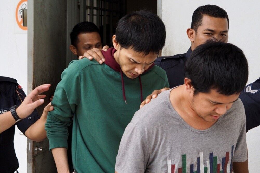 Anggota polis Malaysia mengiringi Ahmad Naim Zaid (berbaju kelabu) dan Mohd Azmer Ramlan beredar keluar dari kamar mahkamah di Sepang, Malaysia, 17 Disember 2019.