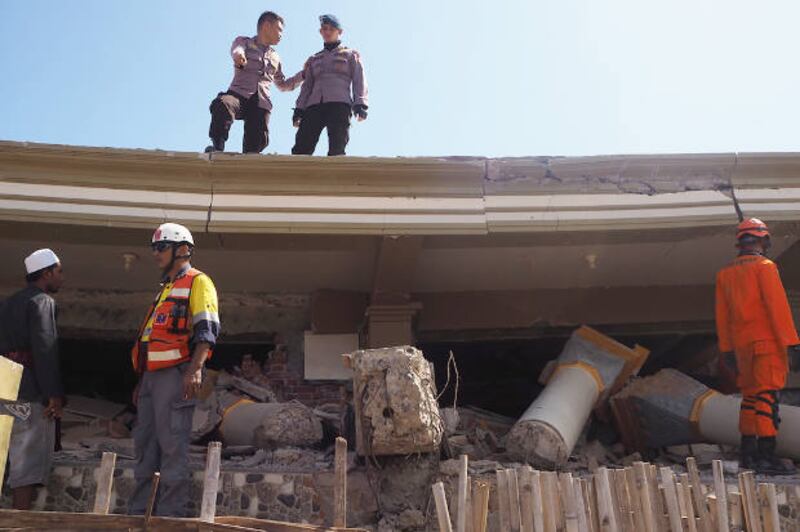 Rescue workers search for survivors in the rubbles of a building that pancaked after powerful earthquake struck North Lombok in Indonesia's West Nusa Tenggara province, Aug. 7, 2018. [Anton Muhajir/BenarNews]