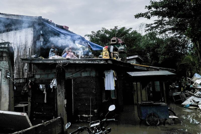 Residents of Linao East, a village in Tuguegarao, Philippines, cook a meal on the roof of their home, Nov. 16, 2020. [Jojo Rinoza/BenarNews]
