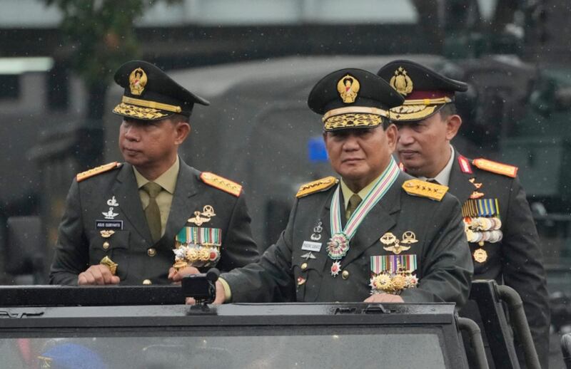 Presiden terpilih Prabowo Subianto (tengah), didampingi oleh Panglima TNI Jenderal Agus Subiyanto (kiri) dan Kapolri Jenderal Listyo Sigit Prabowo, meninjau pasukan setelah menerima pangkat bintang empat dari Presiden Joko “Jokowi” Widodo dalam sebuah upacara di Mabes TNI di Jakarta, 28 Februari 2024. [Achmad Ibrahim/AP]