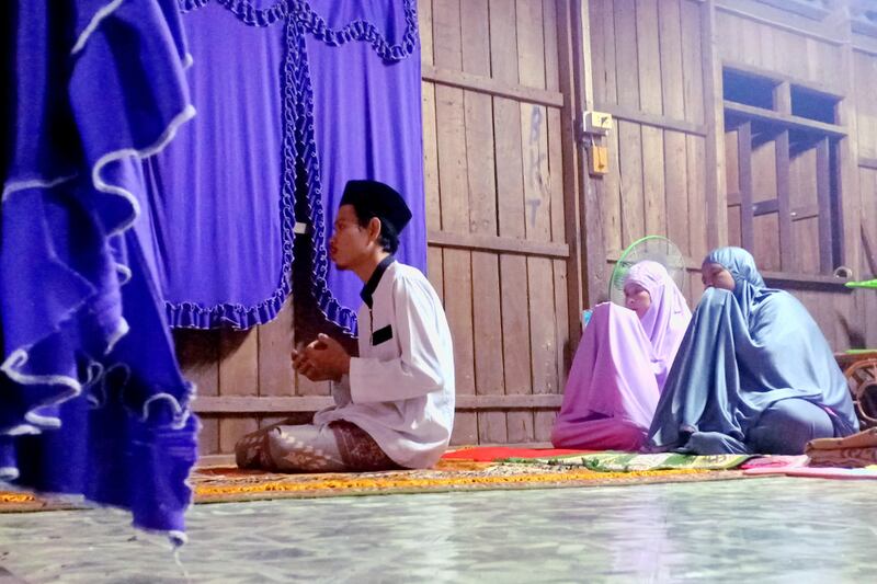 Makoree Abu leads his mother and sister-in-law in Tarawih prayers at his parents' home in Pattani province. April 24, 2020.