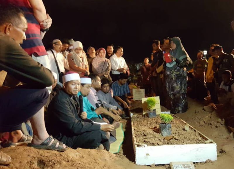 Relatives attend burials of victims of the school fire at Raudhatul Sakinah Muslim burial ground in Kuala Lumpur, Sept 15, 2017.