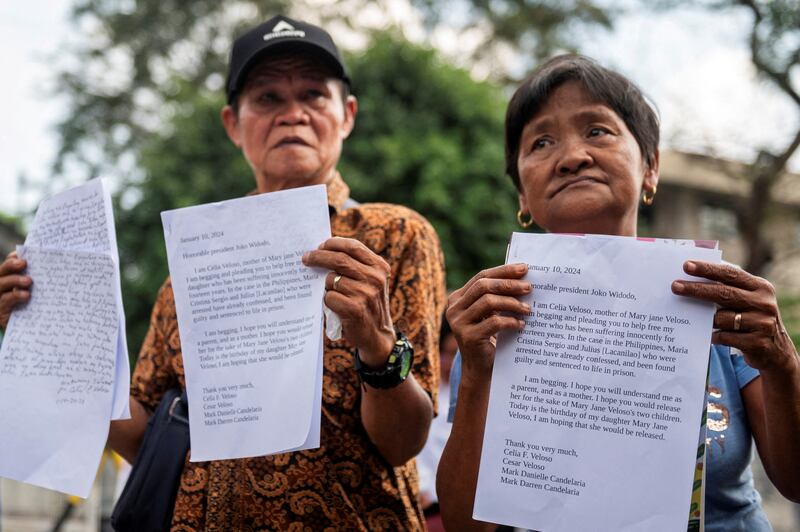 Cesar dan Celia Veloso, orang tua Mary Jane Veloso, memegang salinan surat mereka kepada Presiden Indonesia saat itu Joko Widodo dan Presiden Filipina Ferdinand Marcos Jr., ketika berunjuk rasa menuntut pengampunan bagi putri mereka, yang dijatuhi hukuman mati di Indonesia karena penyelundupan narkoba, di Manila, 10 Januari 2024. [Lisa Marie David/Reuters]