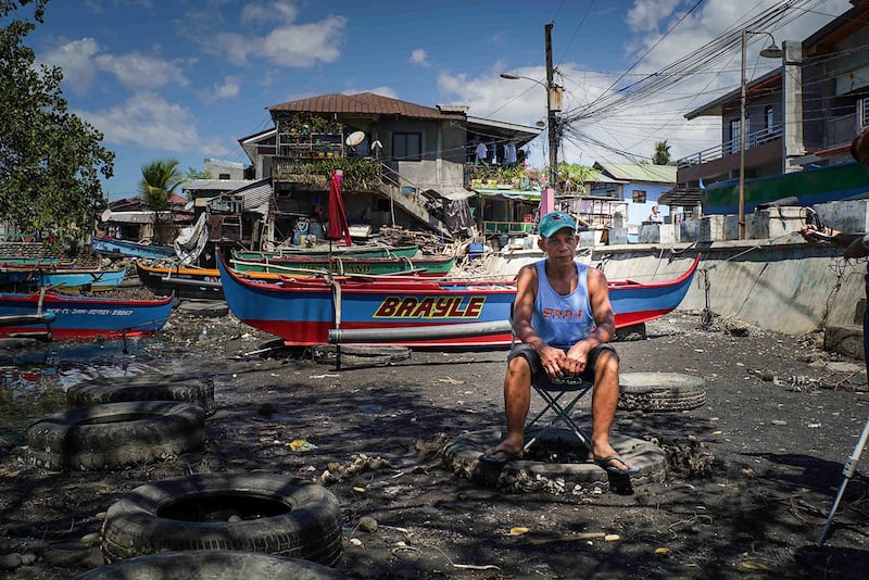 Leonardo Cuaresma, one of the local leaders of the fishermen's group Pamalakaya, sits near the waterside in Masinloc, Feb. 26, 2024. (Jojo Riñoza/BenarNews)