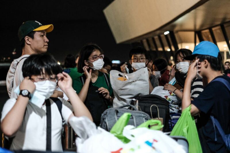 South Korean children on an educational tour in the Philippines are given face masks as a precautionary measure outside Manila's international airport, Jan. 23, 2020. [Jojo Rinoza/BenarNews]