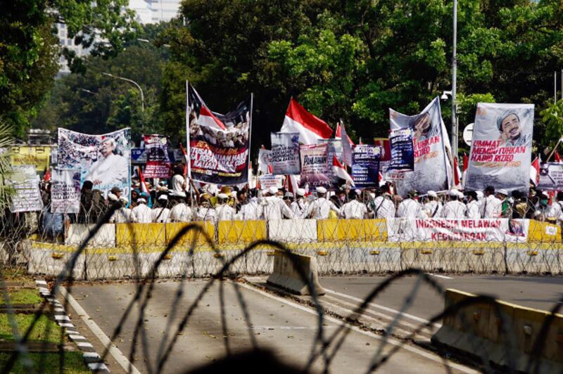Supporters of defeated Indonesian presidential candidate Prabowo Subianto shout out slogans while demonstrating near the Constitutional Court in Jakarta, as a nine-member bench was delivering its verdict on a petition of voter fraud filed by Prabowo's legal team, June 27, 2019. [Arie Firdaus/BenarNews] 