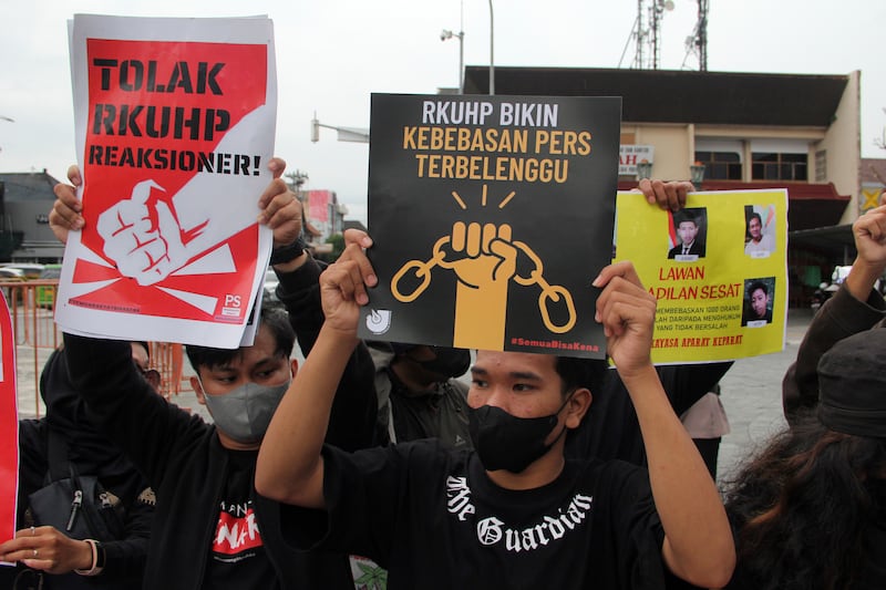 Aktivis mengangkat poster dalam unjuk rasa menentang pengesahan Kitab Undang-Undang Hukum Pidana yang baru, di Yogyakarta, Selasa, 6 Desember 2022. [Slamet Riyadi/AP Photo]
