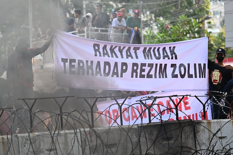 Para aktivis membentangkan spanduk saat melakukan protes di Jakarta pada 26 Oktober 2023 atas keputusan Mahkamah Konstitusi yang mengubah peraturan persyaratan batas usia untuk pencalonan presiden/wakil presiden yang memuluskan jalan bagi Gibran Rakabuming Raka, putra Presiden Joko Widodo, menjadi calon wakil presiden berpasangan dengan Menteri Pertahanan Prabowo Subianto. [Adek Berry/AFP]