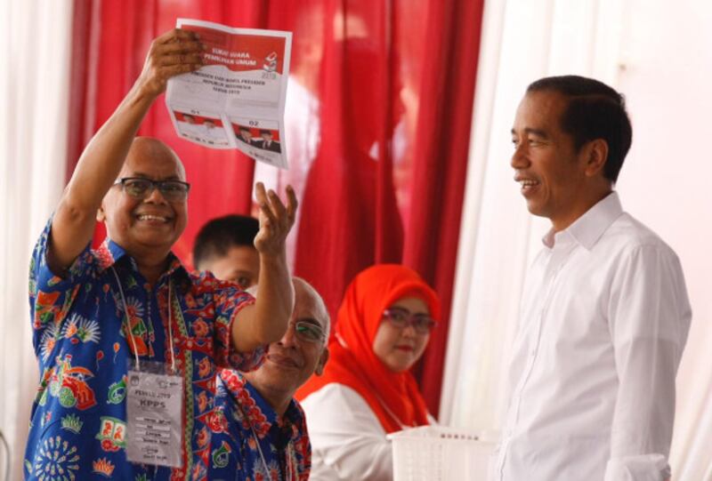 Seorang petugas KPPS memperlihatkan surat suara sebelum memberikannya kepada kandidat petahana, Presiden Joko Widodo di TPS 08, di Lembaga Administrasi Negara, Gambir, Jakarta Pusat, 17 April 2019. (Keisyah Aprilia/BeritaBenar)