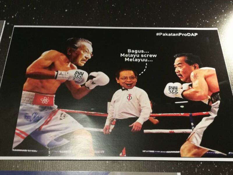 This photo of a poster displayed at UMNO's annual assembly shows a caricature of ex-Prime Minister Mahathir Mohamad (left) boxing with former Deputy Prime Minister Muhyiddin Yassin as Lim Kit Siang, leader of the opposition Democratic Action Party, referees and says in Malay, “Good! Malays screw Malays,” Dec. 6, 2017. (N. Nantha/BenarNews)