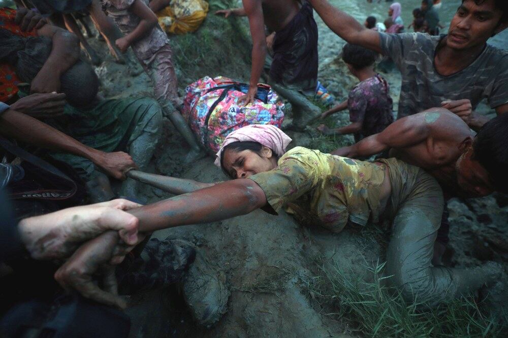 Photographers help pull a Rohingya refugee out of Naf River as she and other refugees tried to cross the Myanmar-Bangladesh border in Palong Khali, near Cox’s Bazar, Bangladesh, Nov. 1, 2017.