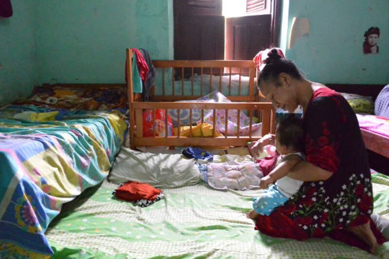 Sarinah, atau “Mak Onah” mengurus Nira yang sudah dianggapnya cucunya sendiri, di Rumah Singgah Kebaya, Yogyakarta, November 2017. (Kusumasari Ayuningtyas/BeritaBenar)