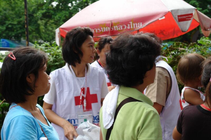 Red Cross members deliver food and medical kits to pro-democracy protesters at the Pathum Wanaram Temple two days before volunteers and protesters were gunned down, May 17, 2010. [Pimuk Rakkanam/BenarNews]