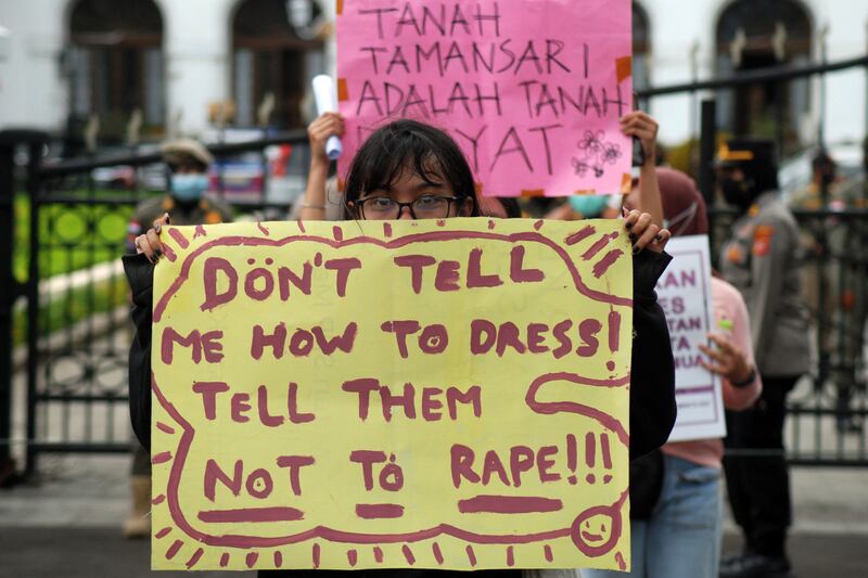 Seorang aktivis mengangkat poster dalam unjuk rasa memperingati Hari Perempuan Internasional di Bandung pada 8 Maret 2021. [Timur Matahari/AFP]