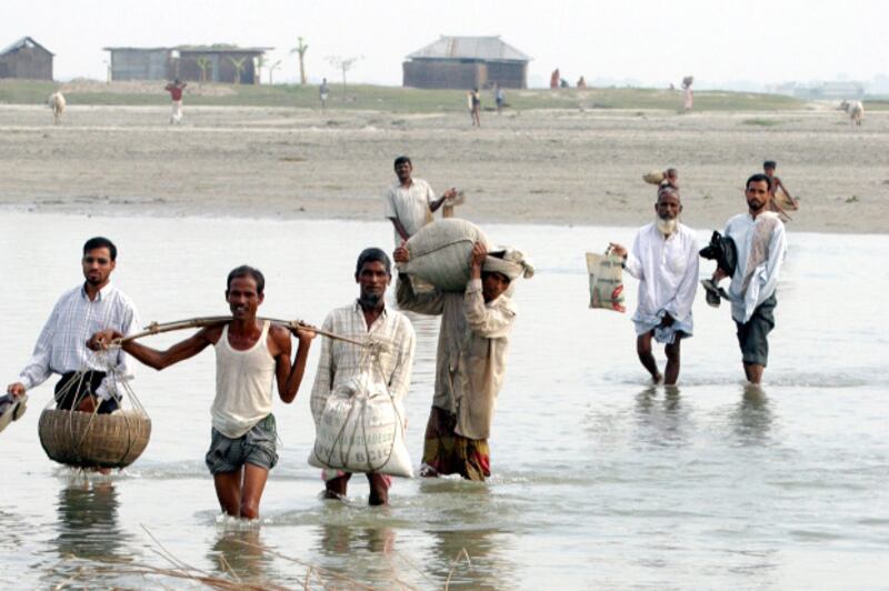 Villagers cross the Teesta River during the dry season in Rangpur district, 214 miles (345 km) north of the Bangladeshi capital Dhaka, Oct. 15, 2005. [Reuters]