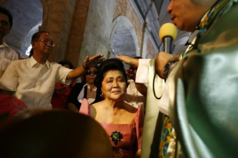 Ecumenical leaders pray over former Philippine first lady Imelda Marcos at a church in Manila's Tondo district, in this undated file photo. [Luis Liwanag/BenarNews] 