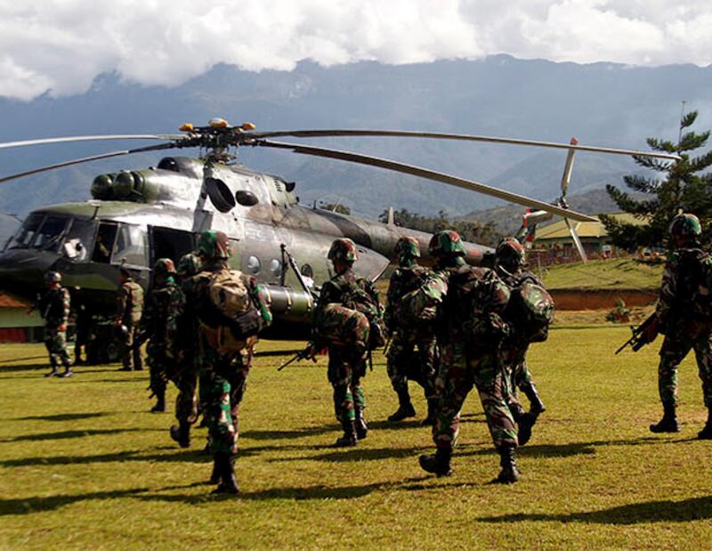 Indonesian soldiers carry rifles as they walk toward a helicopter to fly to Nduga district in Papua province, Dec. 5, 2018. [Antara Foto/Iwan Adisaputra via Reuters]